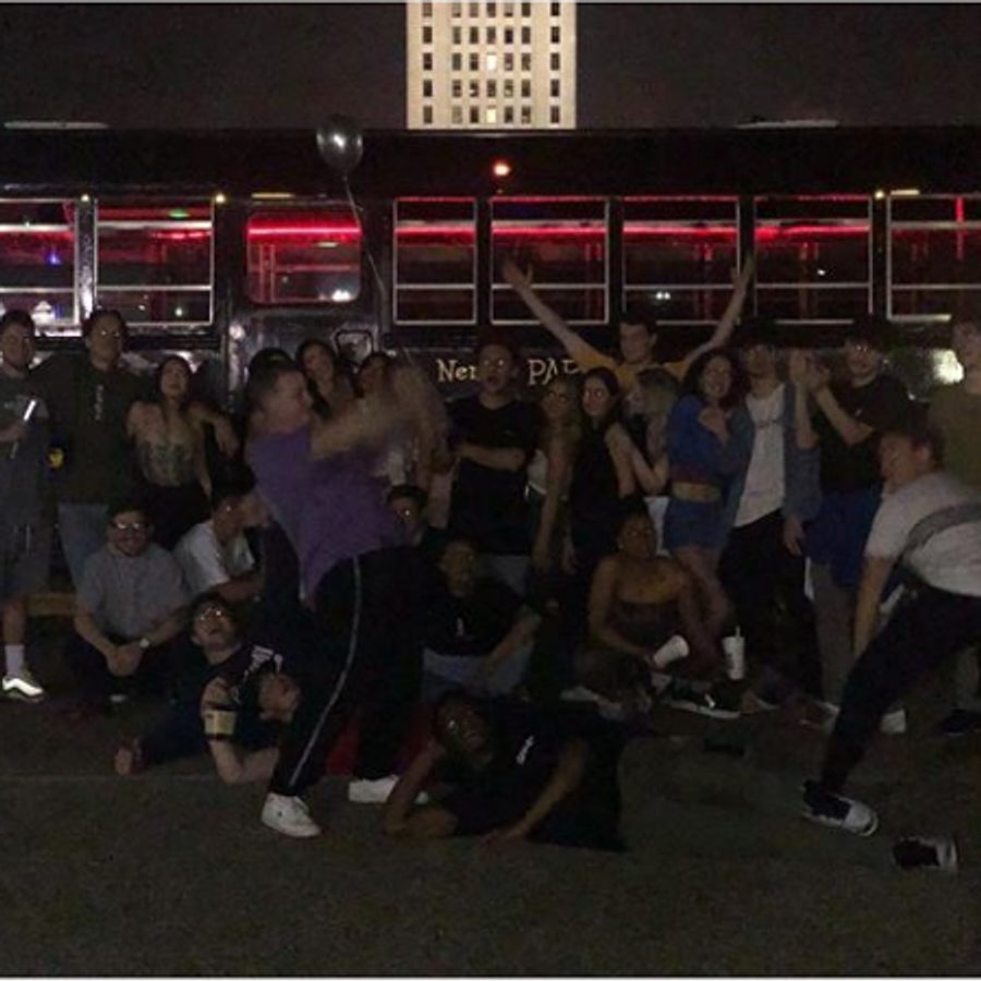 Large group photo outside Nene's Party Bus at night